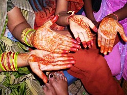 India, land of many traditions and customs. Here women proudly display their mehndi (henna) colored hands on the way to a marriage ceremony. 