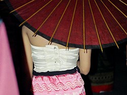 Thailand  - Thai lady in silk clothes with a traditional umbrella.