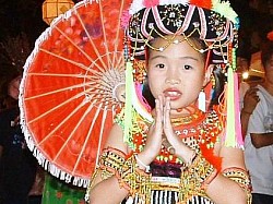 Thailand - girl in traditional hill-tribe dress, in the customary 'Sawadi Kah' greeting. 